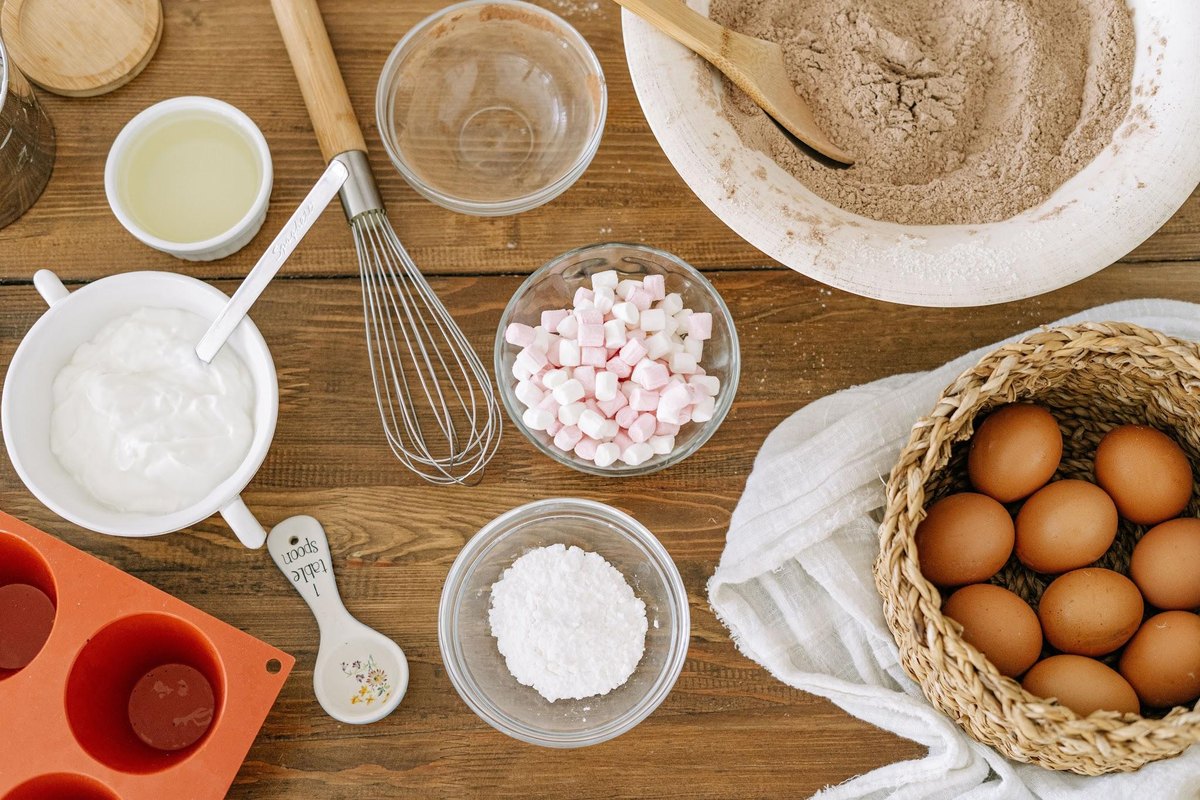 Flat lay of baking essentials including eggs, flour, and utensils. Flat lay of baking essentials including eggs, flour, and utensils.